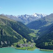 graun am reschensee dahinter langtaufers und weisskugel