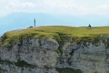 radfahrer am monte roen gipfelkreuz